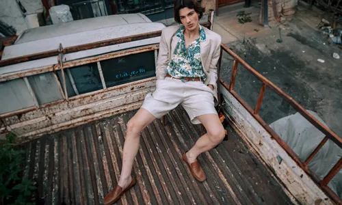 Man-with-green-printed-shirt-white-trousers-wearing-brown-loafers