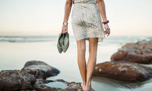 Women-in-beach-with-slippers-in-hand