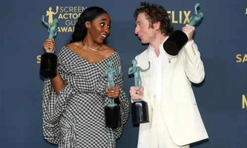 Man and women holding awards in both hands