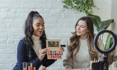 Girl with eyeshadow palette in front of ring light