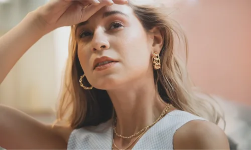 Women wearing gold earring and chain