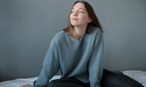girl-in-sweats-and-socks-sitting-in-bed
