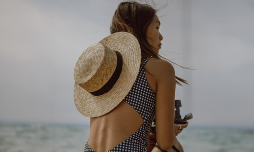 Girl-in-swimsuit-with-hat-on-her-back
