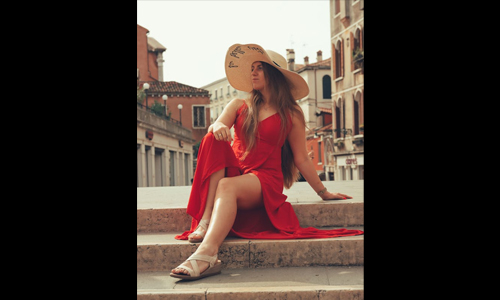 Woman in red dress wearing large hat