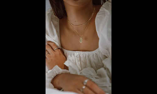 Woman in white dress wearing gold jewelry